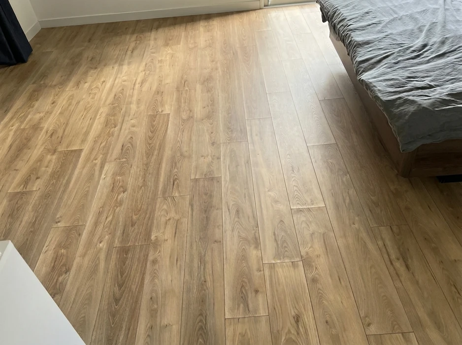 Chambre résidentielle avec parquet stratifié posé en quinconce, teinte chêne naturel doré