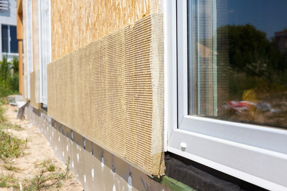 Chantier de construction extérieur montrant l'isolation thermique par l'extérieur d'un bâtiment résidentiel