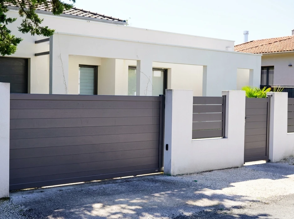 Portail coulissant aluminium laqué gris anthracite à lames horizontales pleines, monté sur piliers béton enduit blanc