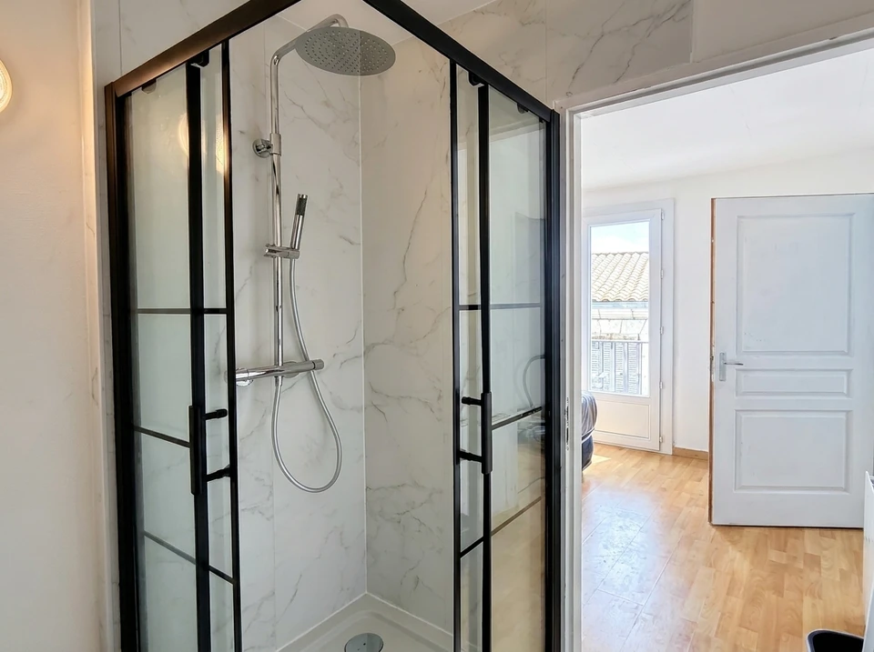Salle de bain PMR moderne aux murs et sol en béton ciré gris clair