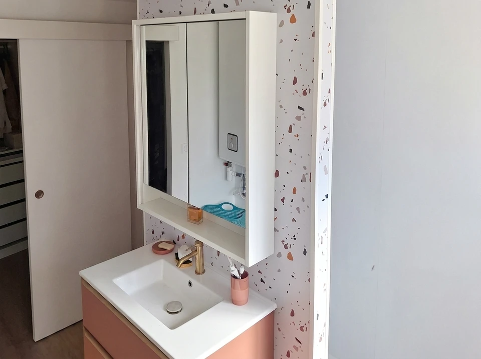 Salle de bain moderne avec douche à l'italienne vitrée, vasque en verre bleu translucide posée sur meuble suspendu blanc