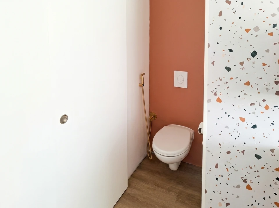Salle de bain moderne avec douche à l'italienne vitrée, vasque en verre bleu translucide posée sur meuble suspendu blanc