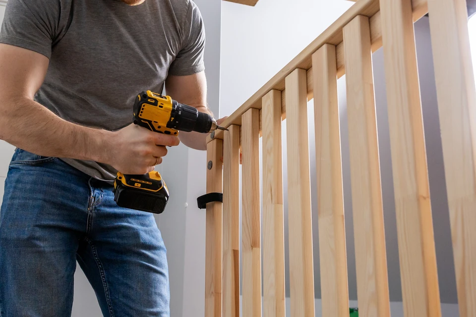 Extérieur résidentiel avec portail coulissant en bois rouge-brun à lames verticales, intégré dans clôture en blocs de béton beige